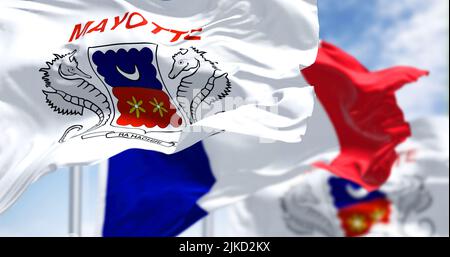 Flaggen von Mayotte winken im Wind mit der französischen Nationalflagge an einem klaren Tag. Mayotte ist ein überseeisches Departement und eine Region und ein einziges territoriales c Stockfoto