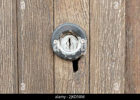 Altes kleines rundes Schlüsselloch an einer antiken, abgenutzten Holztür aus nächster Nähe, Schlüsselloch, einfache Ansicht des Schlosses, Nahaufnahme des Objekts, Frontalaufnahme, Details der Türen, Ro Stockfoto