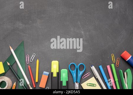 Zurück zum Schulhintergrund mit Kopierplatz. Verschiedene Büro- und Schulmaterialien mit Blackboard-Hintergrund Stockfoto