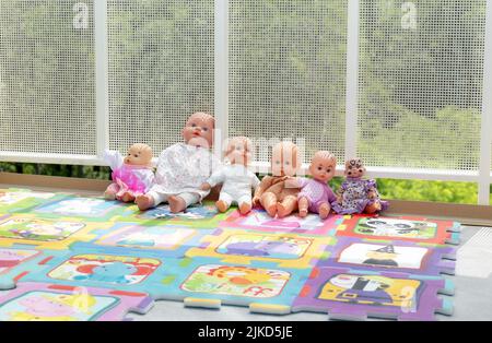 Eine Reihe von kleinen Spielzeugpuppen, Kinderspielzeug, eine Gruppe von Objekten aus der Nähe, niemand, keine Menschen. Kinder Spielzeug in einer Reihe im Freien, Kindergarten, Vorschule spielen einfache Konz Stockfoto