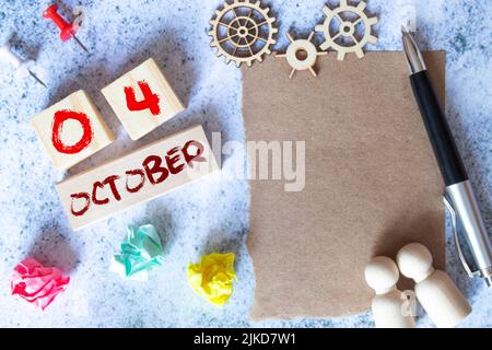 Oktober 4.. Tag 4 des Monats, Kalenderdatum. Notizbuch mit Spirale und Stift liegt auf gelb-blauem Hintergrund. Stockfoto