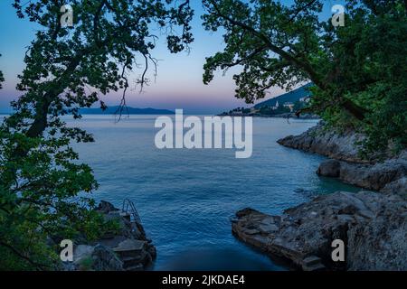 Blick auf Lovran und die Insel Krk im Hintergrund bei Sonnenuntergang, Lovran, Kvarner Bucht, Ostistrien, Kroatien, Europa Stockfoto