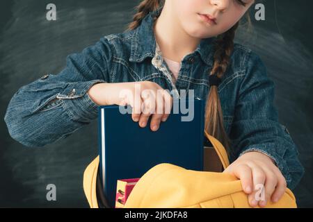 Zurück zur Schule Mädchen Verpackung Bücher Rucksack Stockfoto