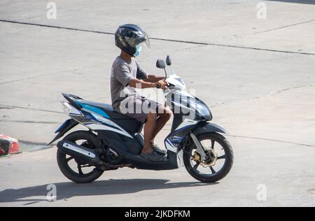 SAMUT PRAKAN, THAILAND, MAI 30 2022, Ein Mann mit Helm fährt ein Motorrad auf der sonnigen Straße Stockfoto