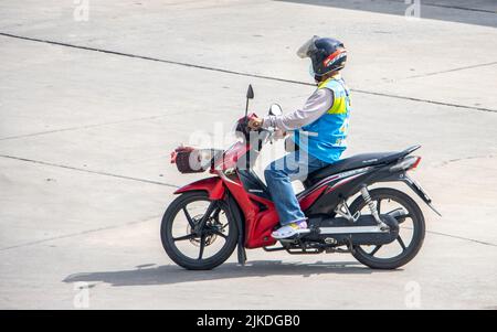 SAMUT PRAKAN, THAILAND, MAI 30 2022, der Mototaxi-Fahrer in einer blauen Weste fährt auf der Straße Stockfoto