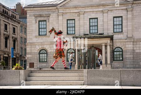 Montreal, Kanada - 13. Juli 2022: Schauspieler in schottischer Militäruniform vor dem Place Royale, der Dudelsäcke spielt Stockfoto