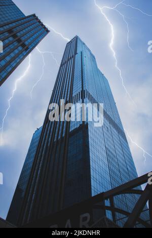 Ein vertikaler, niedriger Winkel von Abu Dhabi Plaza, nur-Sultan, Kasachstan mit Blitz am Himmel Stockfoto