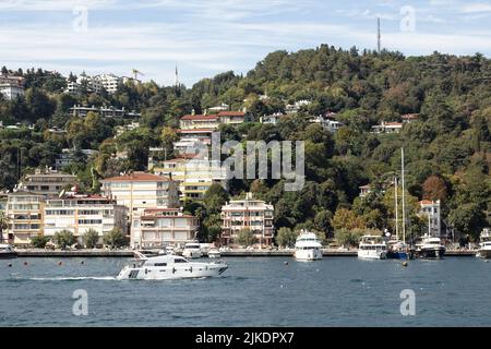 Blick auf eine Yacht, die auf dem Bosporus und Bebek Viertel auf der europäischen Seite von Istanbul vorbeifährt. Es ist ein sonniger Sommertag. Wunderschöne Reiseszene. Stockfoto