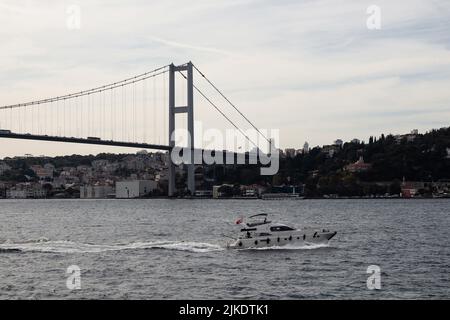 Blick auf eine Yacht auf dem Bosporus, der Brücke und der europäischen Seite Istanbuls. Es ist ein sonniger Sommertag. Wunderschöne Szene. Stockfoto