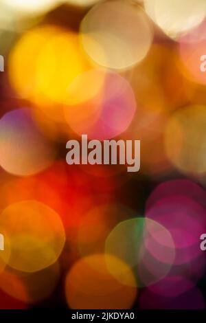 Nahaufnahme der Lichter der Stadt in der Nacht im Hintergrund mit farbigen Neonlichtern, verschwommener Fokus Stockfoto
