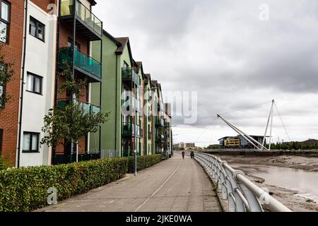 Moderne Apartmentgebäude entlang des Flusses Usk und der Newport City Footbridge, Newport, Monmouthshire, South Wales, Großbritannien. Stockfoto