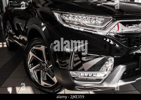 Vorne rechts moderner Scheinwerfer auf Luxus-schwarzen Neuwagen im Automobilsalon. Detail Metallic Stoßstange Auto mit LED-Scheinwerfer und Autorad. Autom. Außen Stockfoto