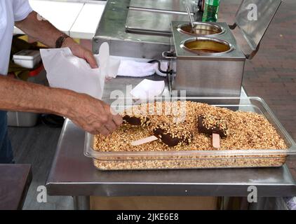 Ein „Nutty Buddy“-Lebensmittelhändler verkauft auf einem Outdoor-Festival in Santa Fe, New Mexico, Vanilleeis-Riegel, die mit Schokolade und Erdnüssen überzogen sind. Stockfoto