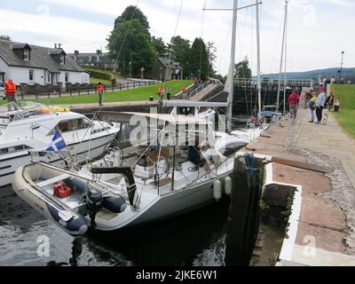 Nahaufnahme einer Yacht und eines Motorkreuzfahrers in einer der Schleusen von Fort Augustus am Caledonian Canal, wo der Wasserspiegel vom Loch Ness steigt. Stockfoto