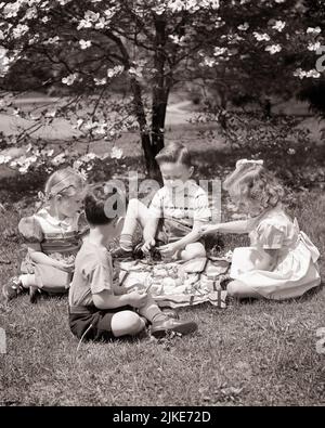 1950S ZWEI JUNGEN UND ZWEI MÄDCHEN BEI EINEM PICKNICK IM FRÜHLING UNTER EINEM BLÜHENDEN DOGWOOD-BAUM, JUNGEN IN SHORTS UND GIROS KLEIDER - J1309 HAR001 HARS SHORTS JUVENILE STIL FREUND FREUDE LIFESTYLE ZUFRIEDENHEIT FRAUEN LÄNDLICHE NATUR KOPIEREN RAUM FREUNDSCHAFT HALBLANGE MÄNNCHEN SONNIGE B&W KLEIDER GLÜCK HELLE HIGH-ANGLE-ABENTEUER FREIZEIT-UND ERNÄHRUNGSPARKS IM FREIEN VERBRAUCHEN FREUNDLICHE NAHRUNG PICKNICK ZUSAMMENARBEIT WACHSTUM JUGENDLICHE FRÜHLING ZWEISAMKEIT SCHWARZ UND WEISS BLÜHENDE KAUKASISCHE ETHNIE DOGWOOD HAR001 ALTMODISCH Stockfoto