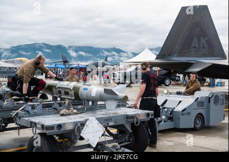 US Air Force Tech. Sgt Luke Markle und die Senior Airmen Kyle Alexander und Brandon Marshall, die Mitglieder der Waffenlastcrew der 90. Aircraft Maintenance Unit sind, treten während der Arctic Thunder Open House auf der Joint Base Elmendorf-Richardson, Alaska, am 31. Juli 2022 an einem Waffenlastwettbewerb an. Diese alle zwei Jahre stattfindende Veranstaltung von JBER ist eine der größten im Bundesstaat und eine der weltweit führenden Luftdemonstrationen. Die Veranstaltung umfasst mehrere Darsteller, darunter das JBER Joint Forces Demonstration Team, das F-22 Raptor Demonstration Team der US Air Force, Pacific Air Forces C-17 Demonstr Stockfoto