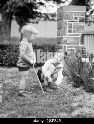 1930S ZWEI KLEINE JUNGEN IM FRÜHLINGSGARTEN - J485 HAR001 HARS FREUNDSCHAFT GANZKÖRPERRAKEN MÄNNCHEN GESCHWISTER VERTRAUEN W&W GÄRTNER HEITER EXTERIEUR ERHOLUNG STOLZ GESCHWISTER LÄCHELT VERBINDUNG KONZEPTIONELL FRÖHLICH STYLISCH ZUSAMMENARBEIT WACHSTUM JUGENDLICHE ZWEISAMKEIT SCHWARZ-WEISS KAUKASISCHE ETHNIE HAR001 ALTMODISCH Stockfoto