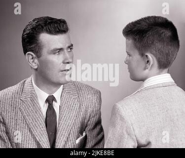 1950S MANN VATER TRÄGT EINEN ANZUG UND RÜCKANSICHT DES JUNGEN SOHN S KOPF MIT EINEM ERNSTHAFTEN VATER UND SOHN VON ANGESICHT ZU ANGESICHT CHAT TALK - J6789 HAR001 HARS WUT KOMMUNIKATION SÖHNE LIFESTYLE ELTERNSCHAFT ZU HAUSE LEBEN HALBZEIT PERSONEN NACHDENKLICH FÜRSORGLICH MÄNNER VERTRAUEN CHAT FATHERS B&W VATERSCHAFT ANZUG UND KRAWATTE STÄRKE UND WAHL KONFRONTATION VÄTER WISSEN MÄCHTIGE RÜCKANSICHT AUTORITÄT KONZEPTIONELL VON HINTEN UNTERSTÜTZUNG BOY'S AUFRICHTIG FEIERLICHE RÜCKANSICHT FOKUSSIERTES WACHSTUM INTENSIVE JUGENDLICHE PRE-TEEN PRE-TEEN JUNGEN LÖSUNGEN SPRECHEN ZWEISAMKEIT SCHWARZ UND WEISS VORSICHTIG KAUKASISCH ETHNIZITÄT ERNSTHAFT HAR001 ABSICHT ALTMODISCH Stockfoto