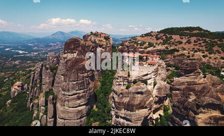 Erstaunliche extreme Drohnenaufnahme von berühmten Felsformationen und Klöstern von Meteora. Schönes Wetter, blauer Himmel. Sommerferien Konzept. Hochwertige Fotos Stockfoto