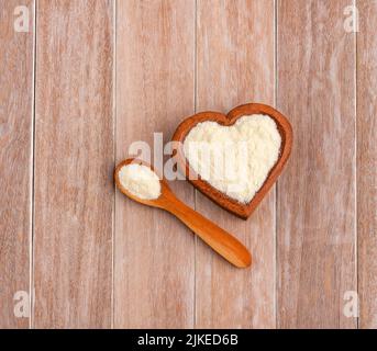 Milchpulver mit Nährstoffen in der herzförmigen Schüssel Stockfoto