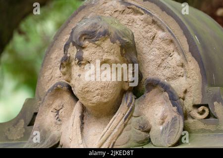 Gruselige antike Engelsfigur mit verwittertem Gesicht auf einem Friedhof in köln-melaten Stockfoto