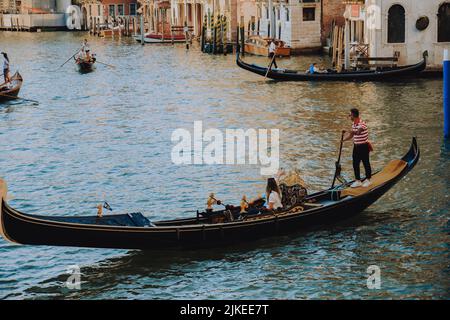 Italien. Venedig. 09.07.2022 Canal Grande In Venedig. Menschen treiben auf Gondeln. Blick auf die Stadt, Reisen Stockfoto