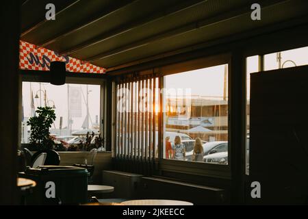 Ein Vibe-Foto von einem Diner bei Sonnenuntergang. Morgens oder am frühen Abend in einem Bistro am Meer Stockfoto