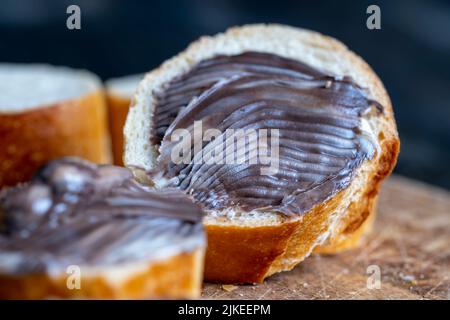 Baguette mit süßer Schokoladenbutter auf einem Brett, einfache Sandwiches mit Baguette garen und mit Schokoladenbutter verschmiert Stockfoto