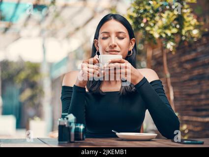 Schöne, glückliche und entspannte Frau, die frischen Kaffee riecht und einen Morgen im Café genießt. Ruhig, Zen und zufrieden Schüler trinken eine warme, heiße und Stockfoto