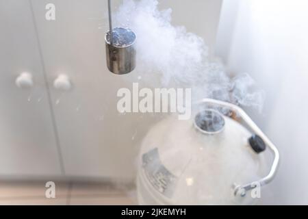 Behälter, der Stickstoff aus einem Tank sammelt, um ihn bei dermatologischen Behandlungen zu verwenden, um Falten oder Muttermale aus der Haut des Patienten in einem Krankenhaus zu entfernen Stockfoto