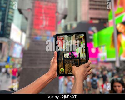 New York, NY, USA. 1. August 2022. Die Menschen erleben am 1. August 2022 eine neue Augmented Reality (AR)-Erfahrung, eine groß angelegte App-basierte Erfahrung, die heute gestartet wurde, um den Times Square, New York City, digital in einen Spielplatz zu verwandeln. (Bild: © Ryan Rahman/Pacific Press via ZUMA Press Wire) Stockfoto