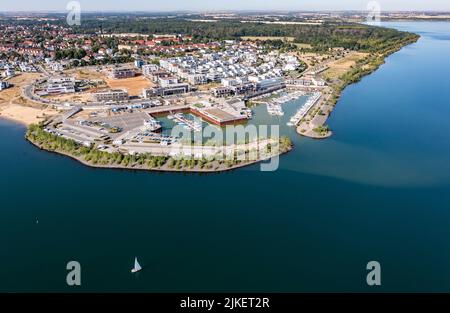 Zwenkau, Deutschland. 19.. Juli 2022. Am Kap Zwenkau am gleichnamigen See wurden ein Hafen und neue Wohngebäude errichtet. Aus dem ehemaligen Braunkohlebergwerk Zwenkau ist mit einer Fläche von fast 10 Quadratkilometern der größte See der Region Leipzig hervorgegossen worden. Seit 2011 wird an der Zwenkau-Küste ein komplett neues Quartier errichtet, das Raum für Wohnen und Arbeiten bieten soll. (Luftaufnahme mit Drohne) Quelle: Jan Woitas/dpa/ZB/dpa/Alamy Live News Stockfoto