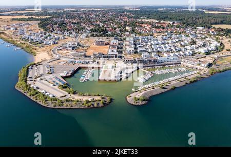 Zwenkau, Deutschland. 19.. Juli 2022. Am Kap Zwenkau am gleichnamigen See wurden ein Hafen und neue Wohngebäude errichtet. Aus dem ehemaligen Braunkohlebergwerk Zwenkau ist mit einer Fläche von fast 10 Quadratkilometern der größte See der Region Leipzig hervorgegossen worden. Seit 2011 wird an der Zwenkau-Küste ein komplett neues Quartier errichtet, das Raum für Wohnen und Arbeiten bieten soll. (Luftaufnahme mit Drohne) Quelle: Jan Woitas/dpa/ZB/dpa/Alamy Live News Stockfoto