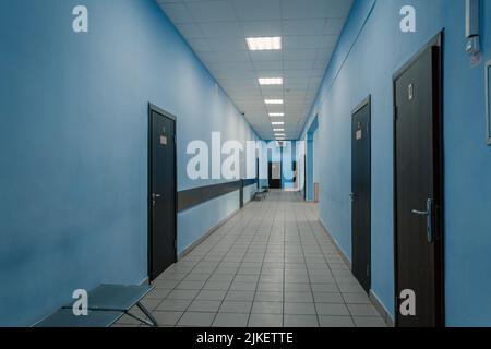 Schulflur, Flur der Hochschule oder Universität. Hellgelbe Wände und braune Türen. Stockfoto