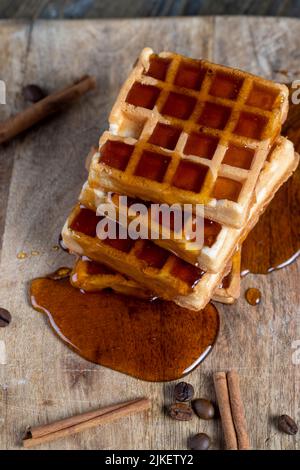 Weiche Waffeln mit natürlichem Bienenhonig auf einem Servierbrett, Kochen mit weichen süßen Waffeln und Bienenhonig Stockfoto