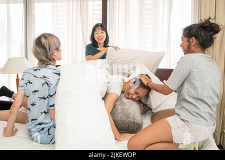 Multi-ethnische Mädchen Kissen kämpfen im Schlafzimmer, schlafen über Partei Konzept. Stockfoto