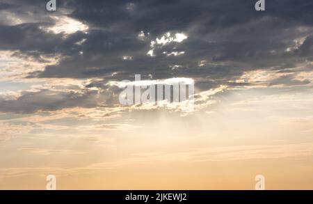 Lichtstrahlen platzen durch eine Wolke Stockfoto