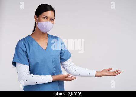 Mein Traum war es, meine Scubs zu tragen, Hochzeitskleider trugen mich. Ein junger Arzt trug eine chirurgische Gesichtsmaske und gestikulte nach links gegen einen weißen Stockfoto
