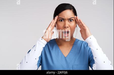 Unwissenheit inspiriert meine ärgerlichste Stimme. Porträt eines gestandenen jungen Arztes in Scrubs vor weißem Hintergrund. Stockfoto