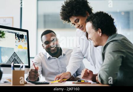 Gemeinsam können wir produktiver sein: Eine Gruppe junger Geschäftsleute, die in einem Büro diskutieren. Stockfoto