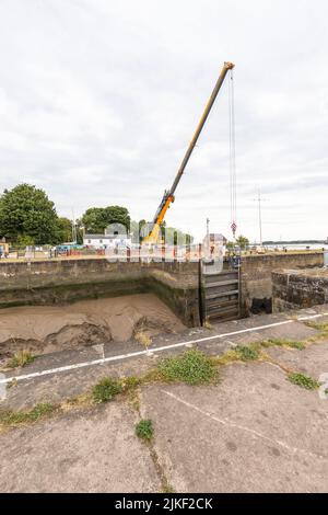 Reparaturen an Schleusentoren von Lydney Harbour. Die Meerestore sind seit langer Zeit gebrochen und werden endlich repariert. Stockfoto