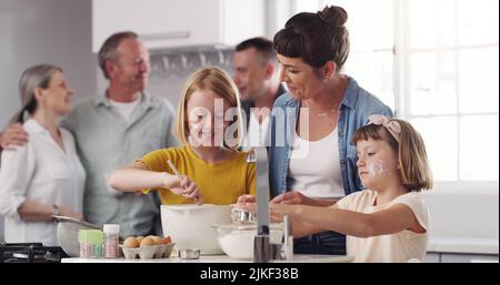 Lasst uns etwas leckeres backen. Eine Familie, die zusammen in der Küche backt. Stockfoto