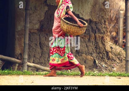 Filmisches Porträt einer Indianerin, die barfuß geht und einen traditionellen gewebten Korb trägt, für Kultur- und Lifestyle-Inhalte. Stockfoto
