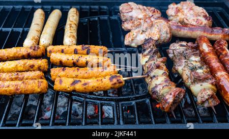 Veganes Essen auf der linken Seite, Fleisch auf der rechten Seite, Barbecue für alle Stockfoto