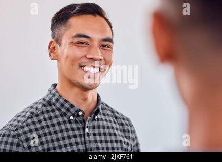 Ein Lächeln kann jeden Tag erhellen. Ein junger Geschäftsmann lächelt in einem Büro. Stockfoto
