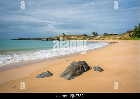 Ein malerischer Blick auf sanft geschwungene Wellen entlang des wunderschönen Haupturlaubsstrandes auf Bremer Island (Dhambaliya) auf der Gove Peninsula in Nordaustralien. Stockfoto