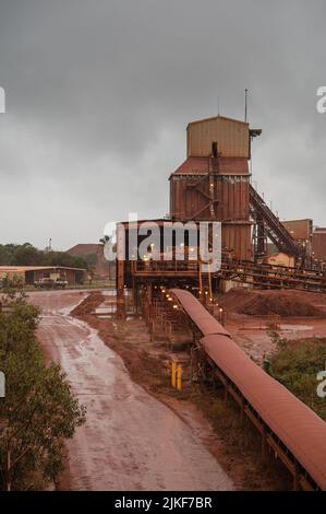 Das nasse Wetter unterstreicht den rot-orangen Staub, der die Bauxit-Raffinerie Nhulunbuy auf der Gove Peninsula im australischen Northern Territory bedeckt. Stockfoto