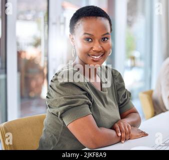 Ich arbeite hart, um meine Ziele zu erreichen. Porträt einer Geschäftsfrau, die lächelt, während sie an ihrem Schreibtisch sitzt. Stockfoto