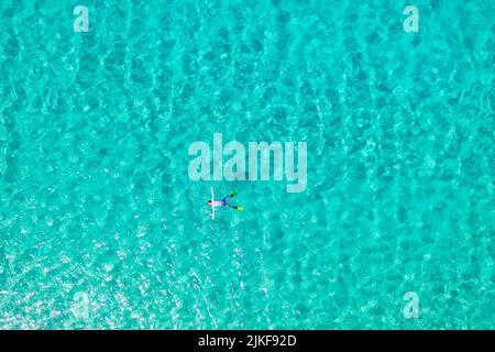 Luftaufnahme eines Jungen, der in einem türkisfarbenen Wasser in einer Bucht in der Nähe des Strandes Veli ZAL, der Insel Dugi otok, Kornati, Kroatien, schwimmte Stockfoto