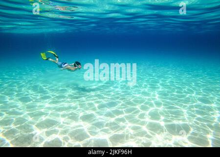 Unterwasserfoto eines Jungen, der mit Schnorchelflossen und einer Schnorchelbrille am wunderschönen Strand von Veli ZAL, Dugi otok, Kroatien, schwimmte Stockfoto